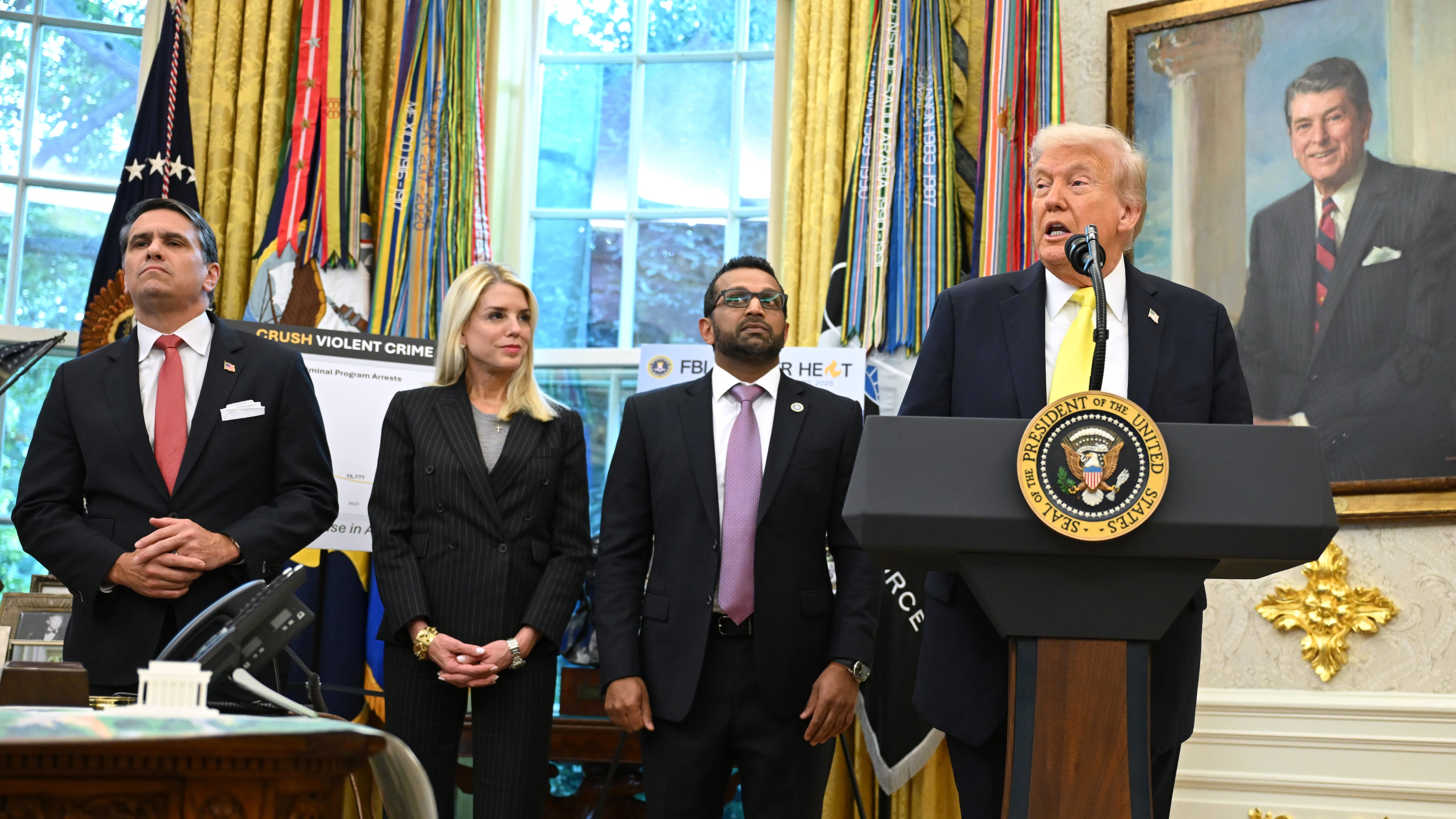 President Donald Trump speaks as FBI Director Kash Patel, Attorney General Pam Bondi, and Deputy Attorney General Todd Blanche listen during an event in the Oval Office at the White House, Wednesday, Oct. 15, 2025, in Washington. (AP Photo/John McDonnell)