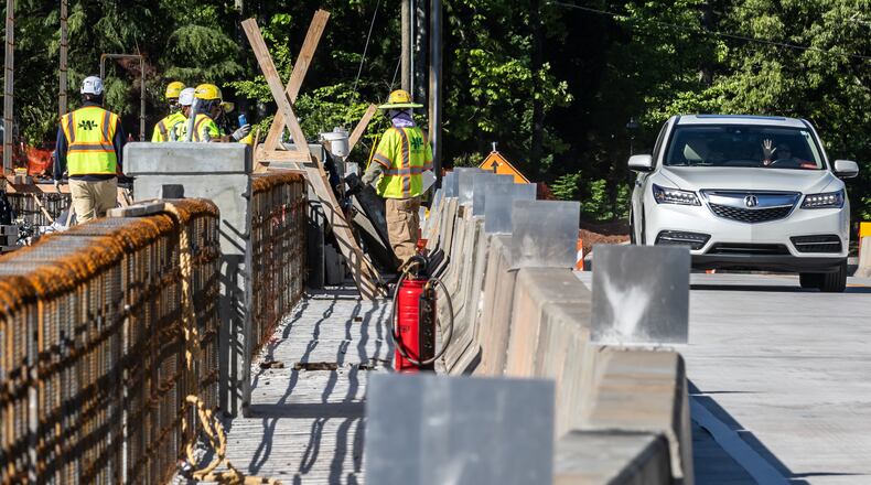 A grateful motorist waves at construction workers after a major connection over Interstate I-285 in Sandy Springs reopened to commuter traffic Monday morning, April 22, 2024, just after 9 a.m. Drivers who use Mt. Vernon Highway began crossing the interstate again after the new bridge opened bringing relief to drivers who have been subject to longer detour delays because of the closing of the  Mt. Vernon Bridge over I-285. Repairs have been ongoing since September when a tractor-trailer hauling an excavator on I-285 hit the underside of the bridge calling into question the integrity of the bridge by officials resulting in its shutdown. The aging bridge was previously scheduled to be replaced as part of the Georgia DOT project to add a new lane on I-285 westbound. The new bridge now has just two lanes, one going in each direction. (John Spink/AJC)