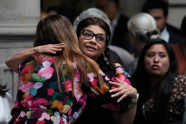 A staff member offers condolences to Mexico City Mayor Clara Brugada, facing camera, at a press conference where she spoke about the assassination of her personal secretary and one of her advisors who were killed earlier in the day by gunmen on a motorcycle, in Mexico City, Tuesday, May 20, 2025. (AP Photo/Marco Ugarte)