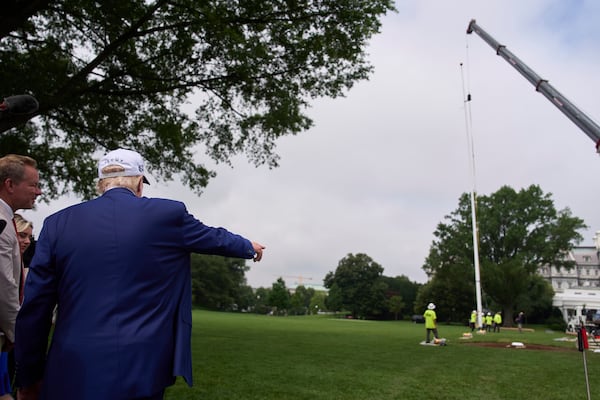 President Donald Trump speaks with reporters as a flag pole is installed on the South Lawn of the White House, Wednesday, June 18, 2025, in Washington. (AP Photo/Evan Vucci)