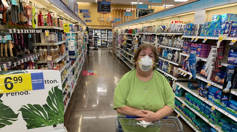 Julie Kirby shopping at the Kroger on Dallas Highway in west Cobb early Wendesday morning. Her pharmacist daughter urged her to don the mask. Jim Galloway, jgalloway@ajc.com
