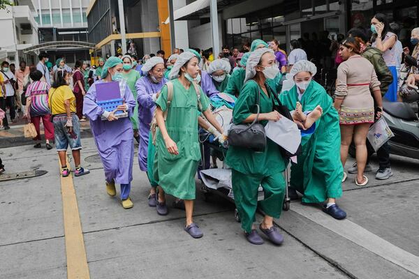 Staff of a police hospital evacuate patients after getting reports of aftershocks in Bangkok, Thailand, Monday, March 31, 2025. (AP Photo/Sakchai Lalit)