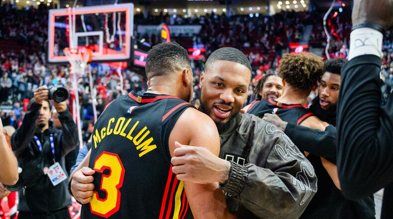 Portland Trail Blazers guard Damian Lillard, right, and Atlanta Hawks guard CJ McCollum, left, embrace after an NBA basketball game on Thursday, Jan. 15, 2026, in Portland, Ore. (AP Photo/Molly J. Smith)