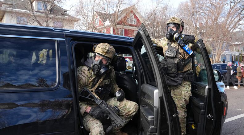 Federal agents get ready to disperse tear gas into a crowd at a protest, Monday, Jan. 12, 2026 in Minneapolis (AP Photo/Adam Gray)