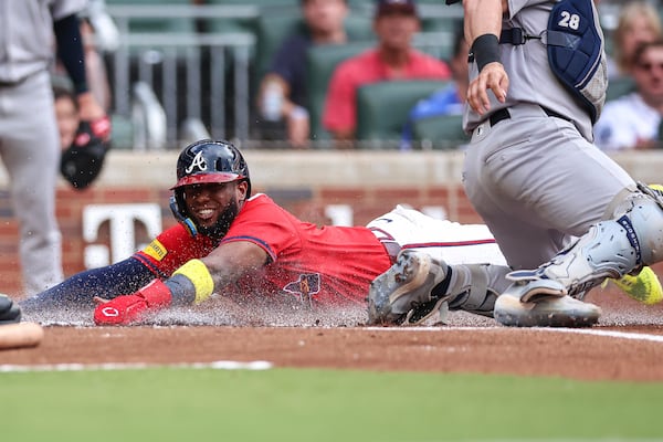 Atlanta Braves' Jurickson Profar, left, slides home ahead of a tag from New York Yankees catcher Austin Wells (28) in the first inning of a baseball game, Friday, July 18, 2025, in Atlanta. (AP Photo/Colin Hubbard)