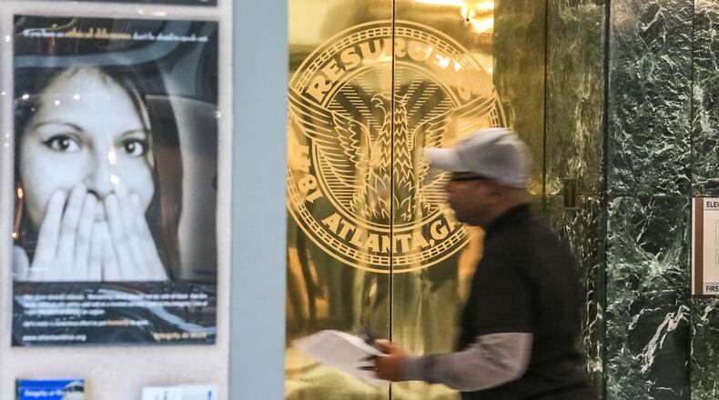 A City of Atlanta employee carries a flier handed out to all workers on Friday, March 23, 2018, telling him and others to turn off their computers because Atlanta was currently amid a ransom hack.