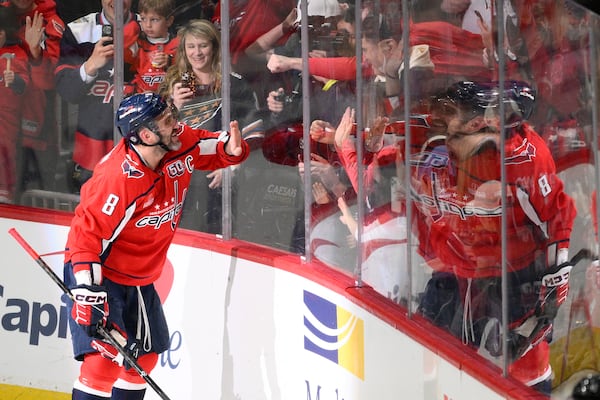 Washington Capitals left wing Alex Ovechkin (8) celebrating his 894th career goal with fans during the third period of an NHL hockey game against the Chicago Blackhawks, Friday, April 4, 2025, in Washington. (AP Photo/Nick Wass)