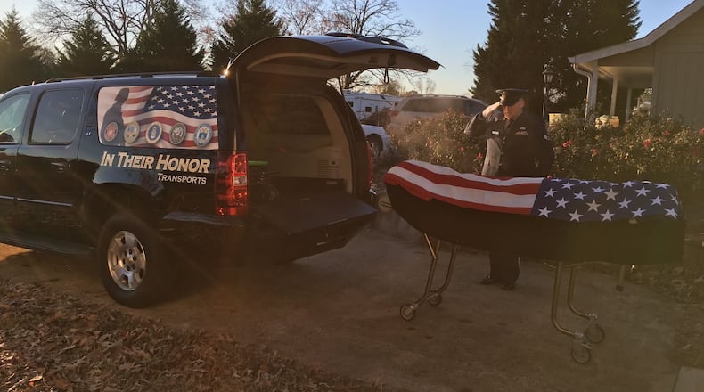 An American flag is placed on a deceased military veteran, who is seen being saluted before being placed in a vehicle for In Their Honor Transports. PROVIDED BY DON WARE