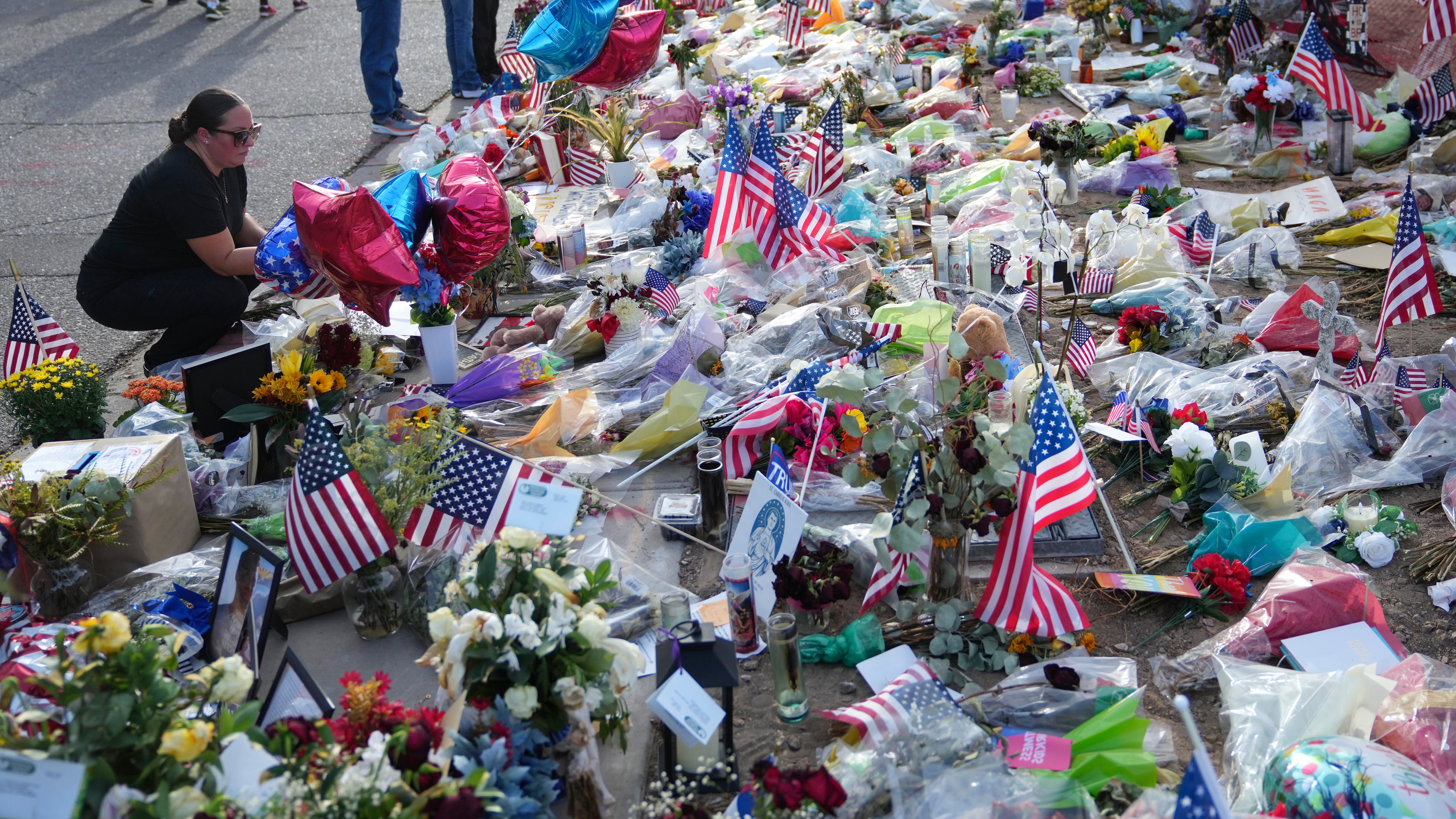 A well-wisher pauses at a growing makeshift memorial set up at the Turning Point USA headquarters after the shooting death at a Utah college last Wednesday of Charlie Kirk, the 31-year-old founder and CEO of the organization, Wednesday, Sept. 17, 2025, in Phoenix. (AP Photo/Ross D. Franklin)