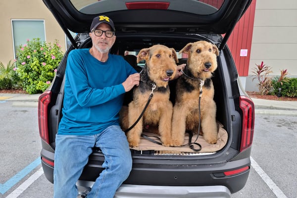 In this undated photo provided by Maida Candler, Bill Cantle poses with his Airedales, Emmett and Molly, in Clearwater, Fla.. (Maida Candler via AP)
