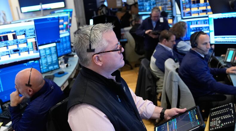 People work on the floor at the New York Stock Exchange in New York, Monday, April 13, 2026. (AP Photo/Seth Wenig)