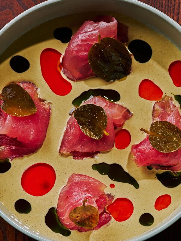 Füm's artistic tuna carpaccio, with little piles of thinly sliced tuna topped with nasturtium leaves and surrounded by swirls of colorful sauce.