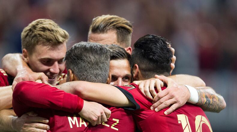 Atlanta United defender Greg Garza (4), center, is surrounded by his teammates after making the first goal for Atlanta United during the match between NYC FC and Atlanta United at Mercedes-Benz Stadium in Atlanta, Georgia, on Sunday, April 15, 2018. (REANN HUBER/REANN.HUBER@AJC.COM)