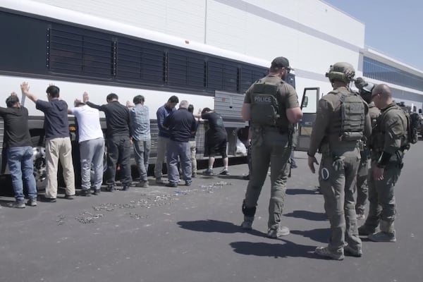 This image from video shows manufacturing plant employees waiting to have their legs shackled at the Hyundai Motor Group’s electric vehicle plant on Thursday, Sept. 4, 2025, in Ellabell. (Corey Bullard/U.S. Immigration and Customs Enforcement via AP)