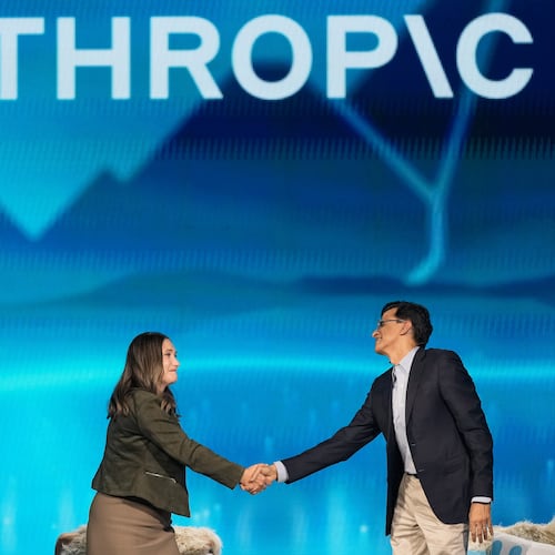 Anthropic co-founder and President Daniela Amodei, left, shakes hands with Snowflake CEO Sridhar Ramaswamy during the keynote presentaton at Snowflake Summit 26 Monday, June 1, 2026, in San Francisco. (AP Photo/Jeff Chiu)