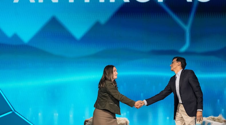 Anthropic co-founder and President Daniela Amodei, left, shakes hands with Snowflake CEO Sridhar Ramaswamy during the keynote presentaton at Snowflake Summit 26 Monday, June 1, 2026, in San Francisco. (AP Photo/Jeff Chiu)