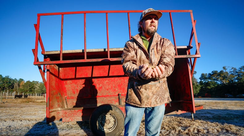 Farm operator Josh Simpson stands in front of cattle feeding troughs on his farm in Dixie in South Georgia. He said he will be watching the next four years closely to see how the incoming Trump administration affects his business. "All I can say is that it can’t be much worse than what we’ve had right now,” said Simpson, who said he is facing higher costs for things such as fertilizer, fuel and labor. (Miguel Martinez / AJC)