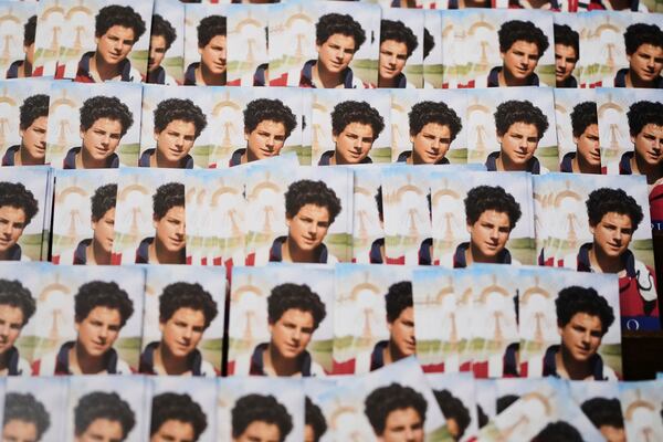 Photos of Carlo Acutis, a 15-year-old Italian boy who died in 2006 of leukemia and beatified in 2020, are displayed at the Santa Maria Maggiore church in Assisi, Italy, Wednesday, April 2, 2025. (AP Photo/Alessandra Tarantino)