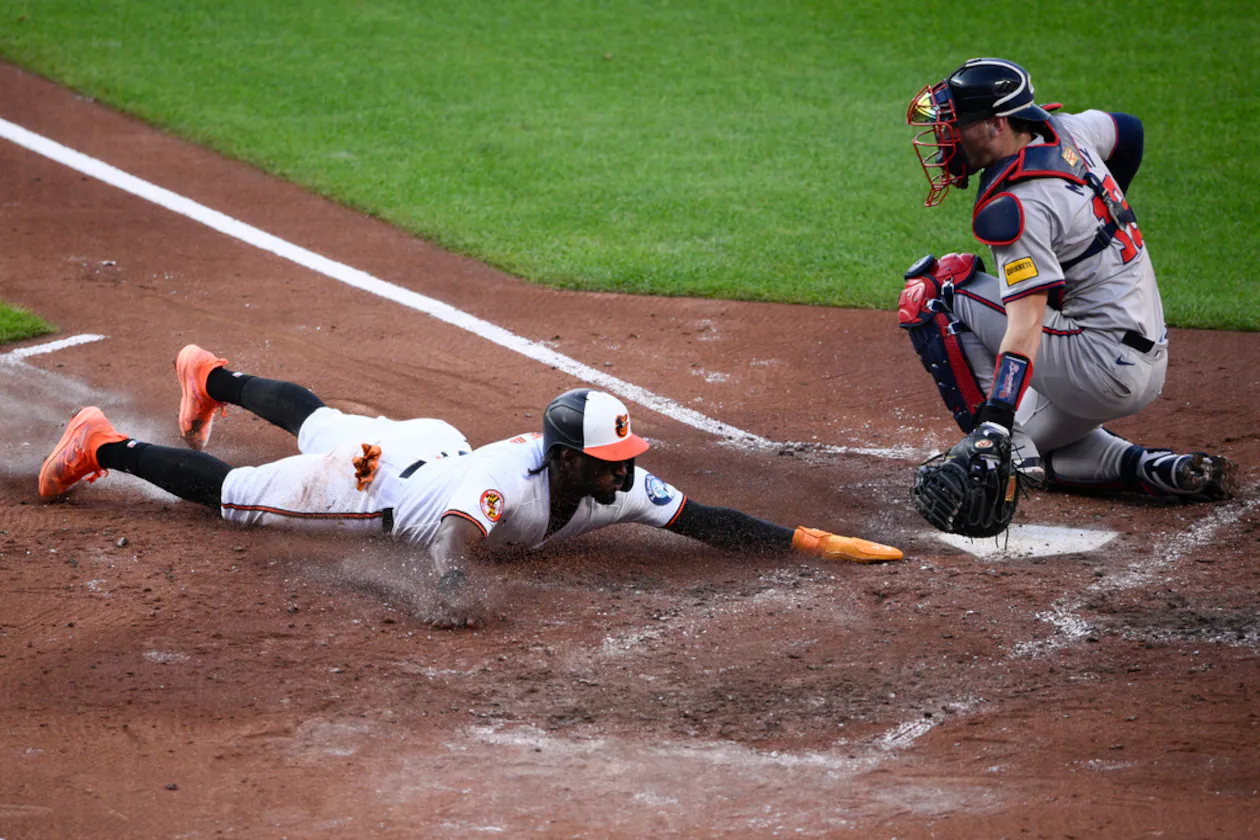 Jorge Mateo (left) — pictured with the Orioles sliding home to score past Braves catcher Sean Murphy in June 2024 — joins the Braves after he was signed Monday. (Nick Wass/AP 2024)