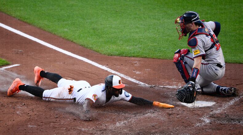 Jorge Mateo (left) — pictured with the Orioles sliding home to score past Braves catcher Sean Murphy in June 2024 — joins the Braves after he was signed Monday. (Nick Wass/AP 2024)