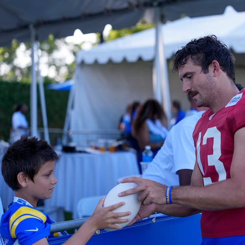 Los Angeles Rams quarterback Stetson Bennett IV (13) interacts with fans after training camp on Friday, July 31, 2026, in Los Angeles. (Miya Tanner via AP)