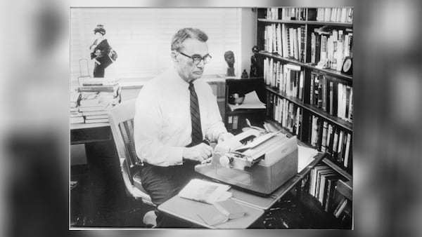 Atlanta Constitution editor Ralph M. McGill writing at his old Royal typewriter. 

Photo originally in color; undated (probably early 1960s); unsigned. Geisha doll in left background. Small bookcase in right background has a sculpted head of John Kennedy, a small Daibutsu from Kamakura (Japan), and an African-looking carving on it. A medium-size silver Revere bowl is on the second shelf. (AJC file)