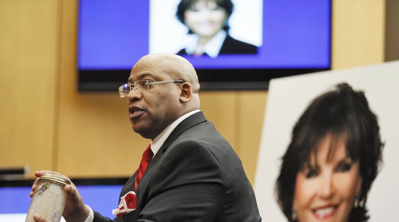 April 17, 2018 - Chief Assistant District Attorney Clint Rucker, with a photo of Diane McIver behind him, holds a jar of sandy water, saying it will be crystal clear when he concludes, as he makes closing arguments for the prosecution during the Tex McIver murder trial at the Fulton County Courthouse.