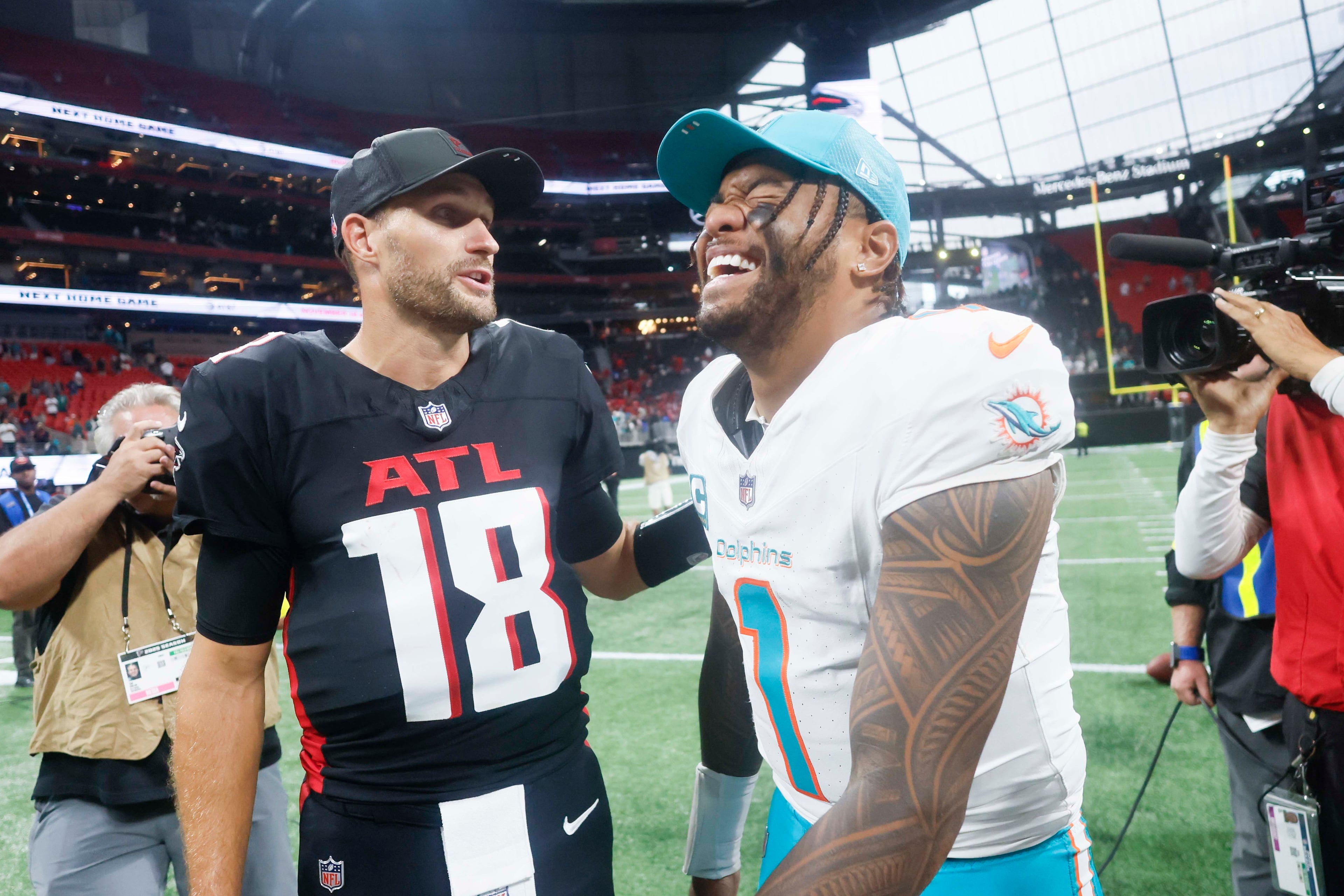 Miami Dolphins quarterback Tua Tagovailoa (right) smiles as he talks with Atlanta Falcons quarterback Kirk Cousins (left) after the game at Mercedes-Benz Stadium in Atlanta on Sunday, Oct. 26, 2025. The Miami Dolphins defeated the Atlanta Falcons 34-10. (Miguel Martinez/AJC)