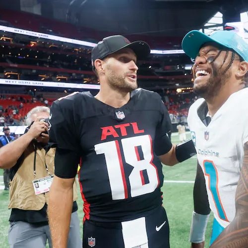 Miami Dolphins quarterback Tua Tagovailoa (right) smiles as he talks with Atlanta Falcons quarterback Kirk Cousins after a game in October 2025. Tagovailoa will give the Falcons two left-handed quarterbacks, along with Michael Penix Jr., who is recovering from an ACL injury. (Miguel Martinez/AJC)
