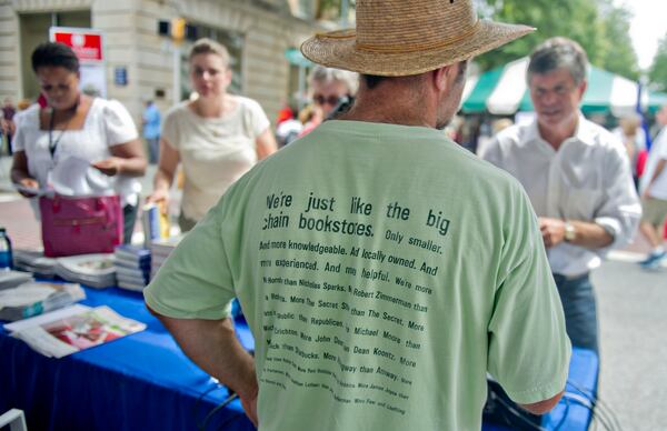 Decatur - Frank Reiss (center) helps customers at the Atlanta Journal-Constitution booth during the AJC Decatur Book Festival on Saturday, August 30, 2014. The annual festival  draws visitors to downtown Decatur area to meet with world-class authors, illustrators, editors, publishers, booksellers, and artists for a weekend filled with literature, music, food, art, and fun.   JONATHAN PHILLIPS / SPECIAL