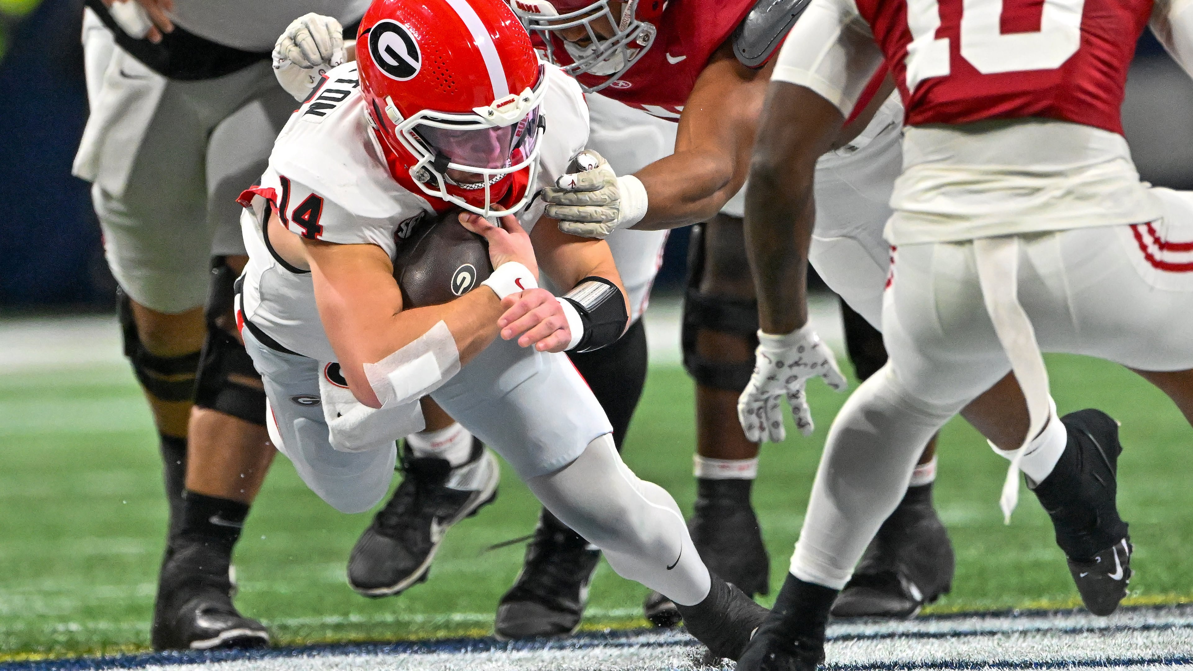 Georgia quarterback Gunner Stockton (14) drives for extra yardage on a keeper play against Alabama defensive lineman Keon Keeley (31) during the first half of the SEC Championship game at Mercedes-Benz Stadium, Saturday, Dec. 6, 2025, in Atlanta. (Hyosub Shin / AJC)