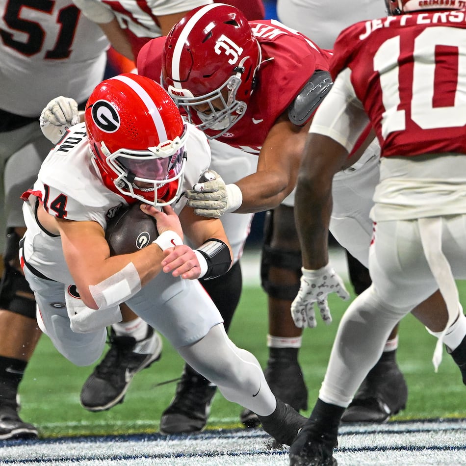 Georgia quarterback Gunner Stockton (14) drives for extra yardage on a keeper play against Alabama defensive lineman Keon Keeley (31) during the first half of the SEC Championship game at Mercedes-Benz Stadium, Saturday, Dec. 6, 2025, in Atlanta. (Hyosub Shin / AJC)