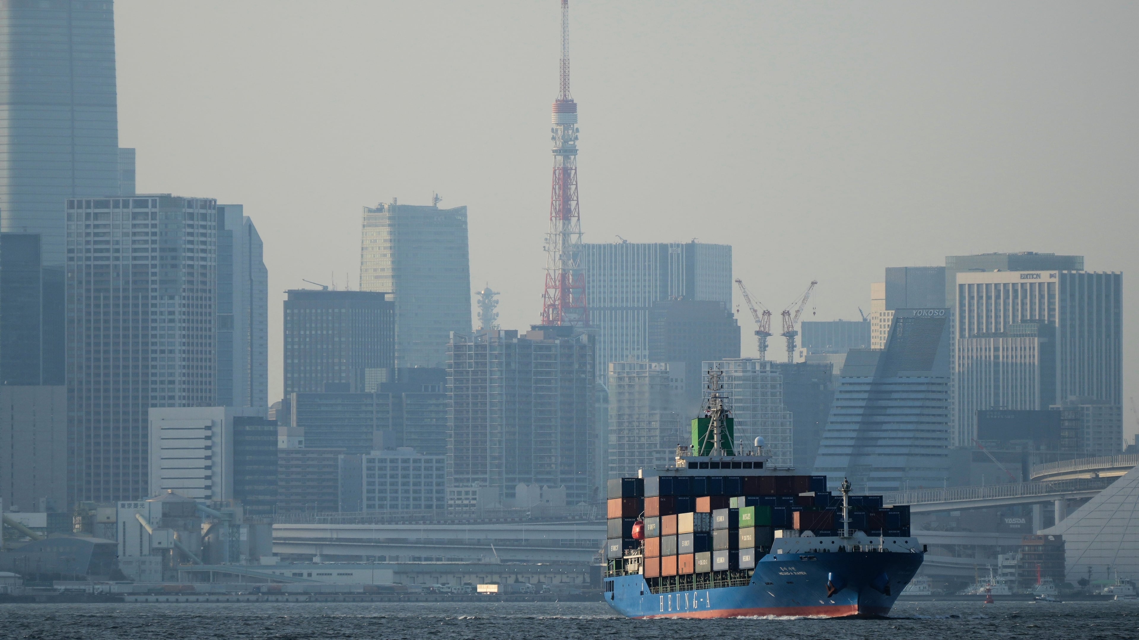 FILE - Tokyo Tower is visible amid tall buildings as a container ship leaves a cargo terminal in Tokyo, April 9, 2025. (AP Photo/Hiro Komae, File)