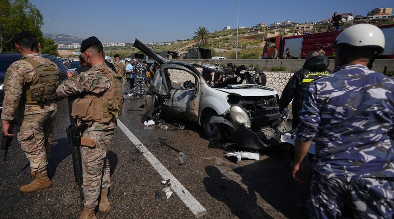 Security forces and emergency responders gather around a damaged vehicle at the scene of an Israeli airstrike that hit a car in the coastal town of Saadiyat, south of Beirut, Lebanon, Saturday, May 9, 2026. (AP Photo/Hassan Ammar)
