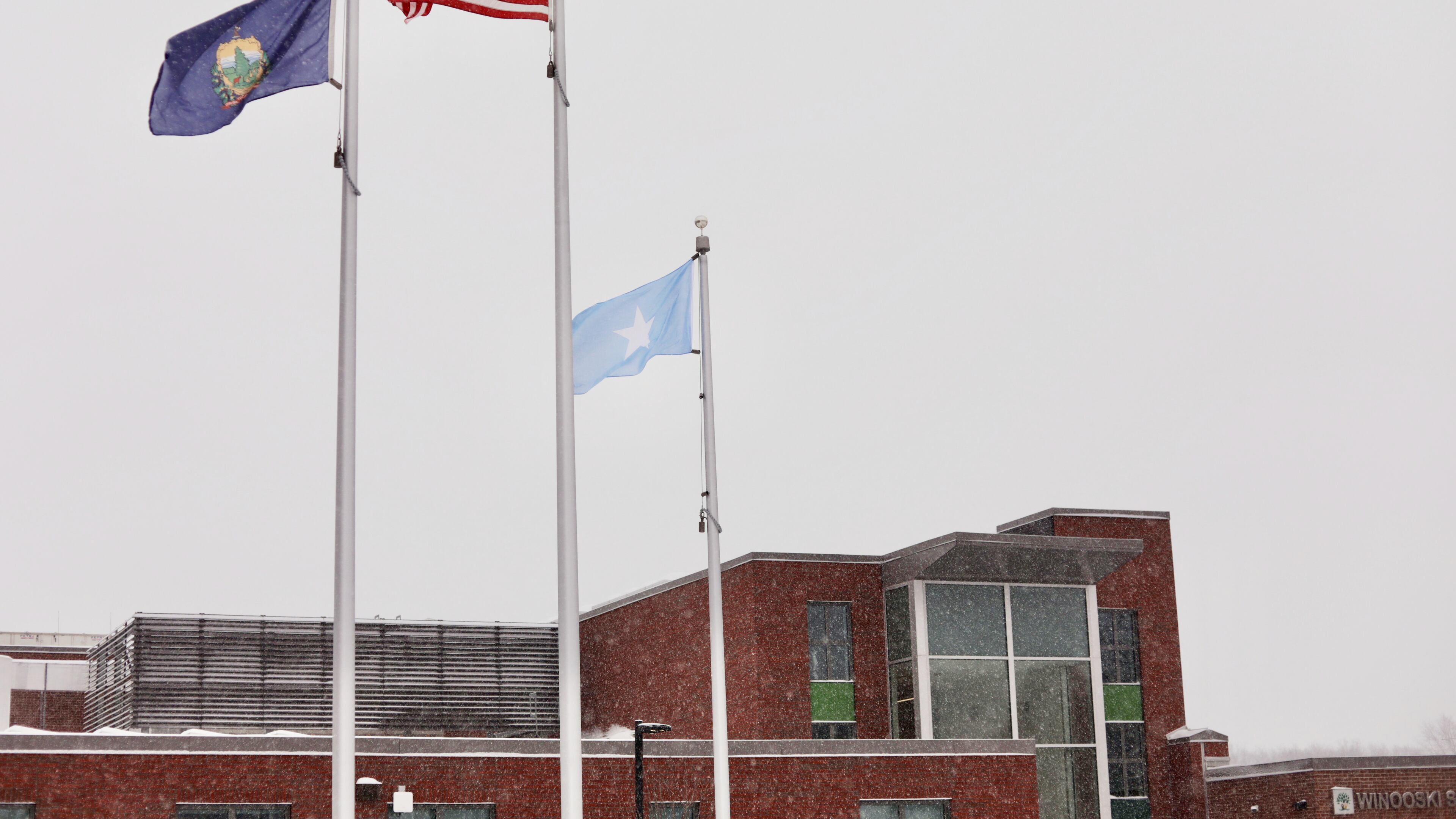 A Somali flag flies alongside the United States and Vermont flags outside the Winooski School District building Wednesday, Dec. 10, 2025, in Winooski, Vt. (AP Photo/Amanda Swinhart)