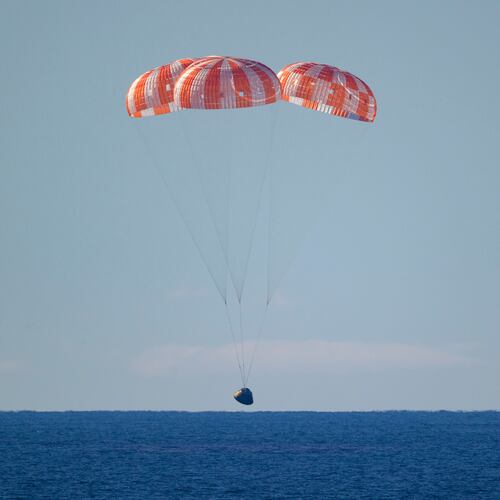 In this photo provided by NASA, the Orion spacecraft with Artemis II crewmembers aboard approaches the surface of the Pacific Ocean for splashdown off the coast of California, Friday, April 10, 2026. (Bill Ingalls/NASA via AP)