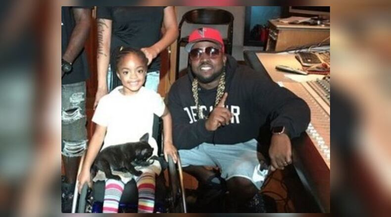 Big Boi (right) gave 5-year-old Abriya Ellison a puppy nearly four months after she was injured in a shooting at a party. (Credit: Channel 2 Action News)