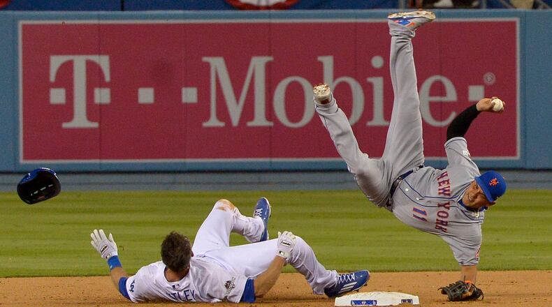 New York Mets shortstop Ruben Tejada falls after a slide by Los Angeles Dodgers' Chase Utley during the seventh inning of an NL Division Series baseball game Saturday, Oct. 10, 2015, in Los Angeles.
