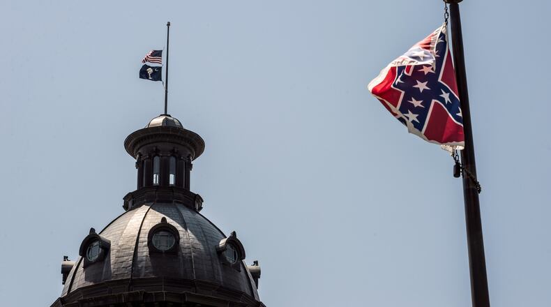 The South Carolina and American flags fly at half-mast as the Confederate flag unfurls below at the Confederate monument June 18, 2015 in Columbia, S.C. Sean Rayford/Getty Images
