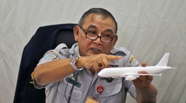 Indonesian National Transportation Safety Committee chief Tatang Kurniadi speaks with a model plane of AirAsia Flight 8501 that crashed into the Java Sea on Dec. 28 last year during a press conference in Jakarta, Indonesia Thursday, Jan. 29, 2015. On Dec. 1, 2015, an investigation concluded that at least one faulty plane part and crew behavior led to the plane going down, killing everyone on board. (AP Photo/Dita Alangkara)