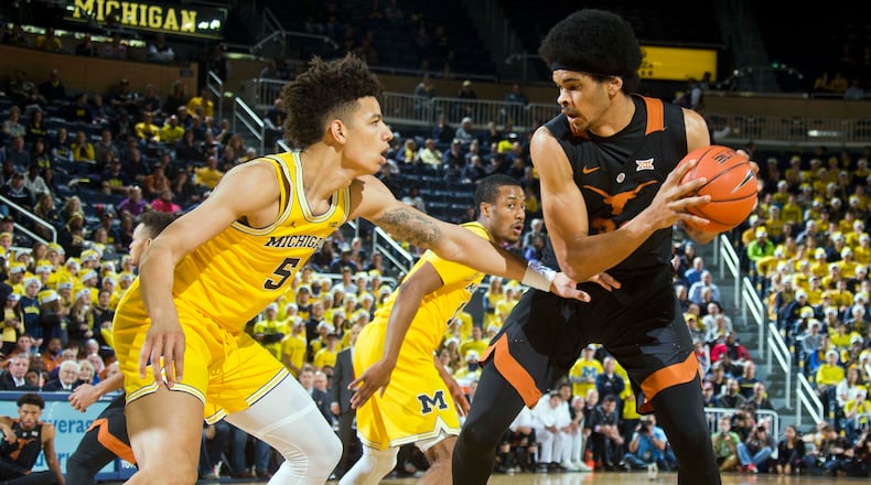Michigan forward D.J. Wilson (5) defends Texas center Jarrett Allen, right, in the first half of an NCAA college basketball game in Ann Arbor, Mich., Tuesday, Dec. 6, 2016. (AP Photo/Tony Ding)