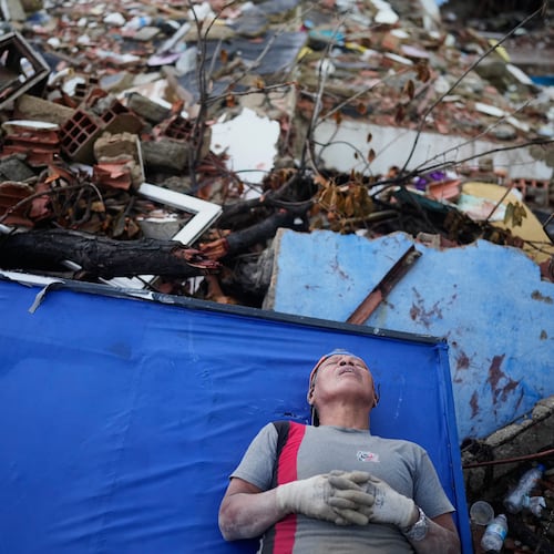 Resident Kerli Faria takes a break amid the rubble while searching for her nephews at a building that collapsed during the earthquakes that struck La Guaira, Venezuela, Tuesday, June 30, 2026. (AP Photo/Ariana Cubillos)