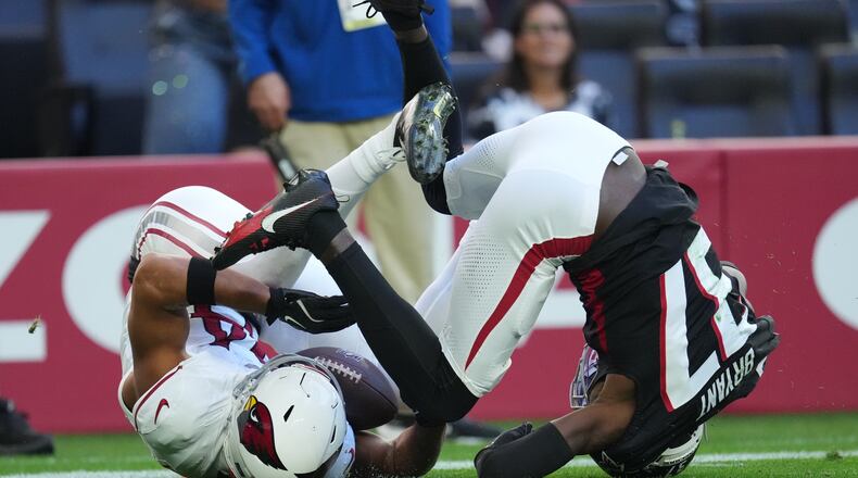 Arizona Cardinals wide receiver Michael Wilson (14) scores a touchdown against Atlanta Falcons cornerback Cobee Bryant (37) during the first half of an NFL football game, Sunday, Dec. 21, 2025, in Glendale, Ariz. (AP Photo/Ross D. Franklin)