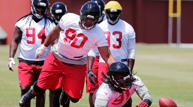 Derrick Shelby, left, knocks the ball away from Falcons teammate Courtney Upshaw during a drill at a practice Monday, May 23, 2016, in Flowery Branch. (AP Photo/David Goldman)