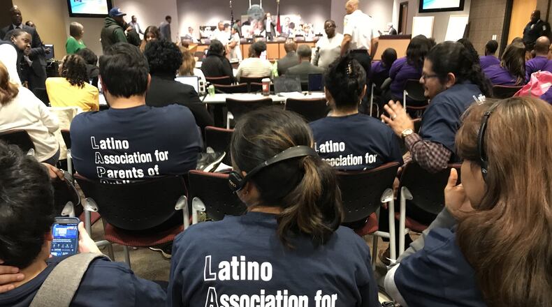 Members of the Latino Association for Parents of Public Schools use headphones to listen to an interpreter during a February meeting of the Atlanta Board of Education. VANESSA McCRAY/VANESSA.MCCRAY@AJC.COM