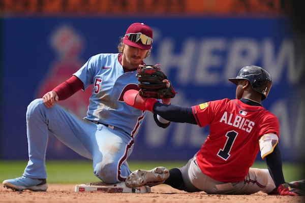 Atlanta Braves' Ozzie Albies, right, is tagged out by Philadelphia Phillies second baseman Bryson Stott after trying to steal second during the ninth inning in the first baseball game of a doubleheader Thursday, May 29, 2025, in Philadelphia. (AP Photo/Matt Slocum)