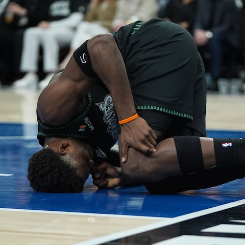 Minnesota Timberwolves guard Anthony Edwards kneels on the court after sustaining an injury during the first half of Game 4 of a first-round NBA basketball playoff series against the Denver Nuggets, Saturday, April 25, 2026, in Minneapolis. (AP Photo/Abbie Parr)