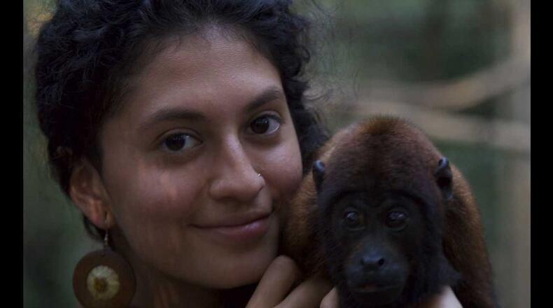 Kimberly Cruz with a baby red howler monkey.