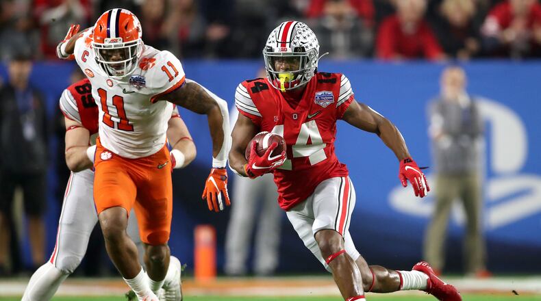 GLENDALE, ARIZONA - DECEMBER 28:  K.J. Hill #14 of the Ohio State Buckeyes carries the ball against Isaiah Simmons #11 of the Clemson Tigers in the first half during the College Football Playoff Semifinal at the PlayStation Fiesta Bowl at State Farm Stadium on December 28, 2019 in Glendale, Arizona. (Photo by Christian Petersen/Getty Images)