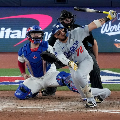 Los Angeles Dodgers' Miguel Rojas follows through on a home run against the Toronto Blue Jays during the ninth inning in Game 7 of baseball's World Series, Saturday, Nov. 1, 2025, in Toronto. (AP Photo/Ashley Landis)